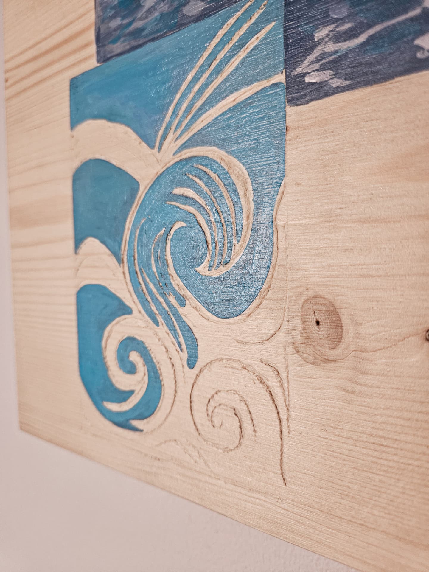 Détail — la vague gravée dans le bois nu