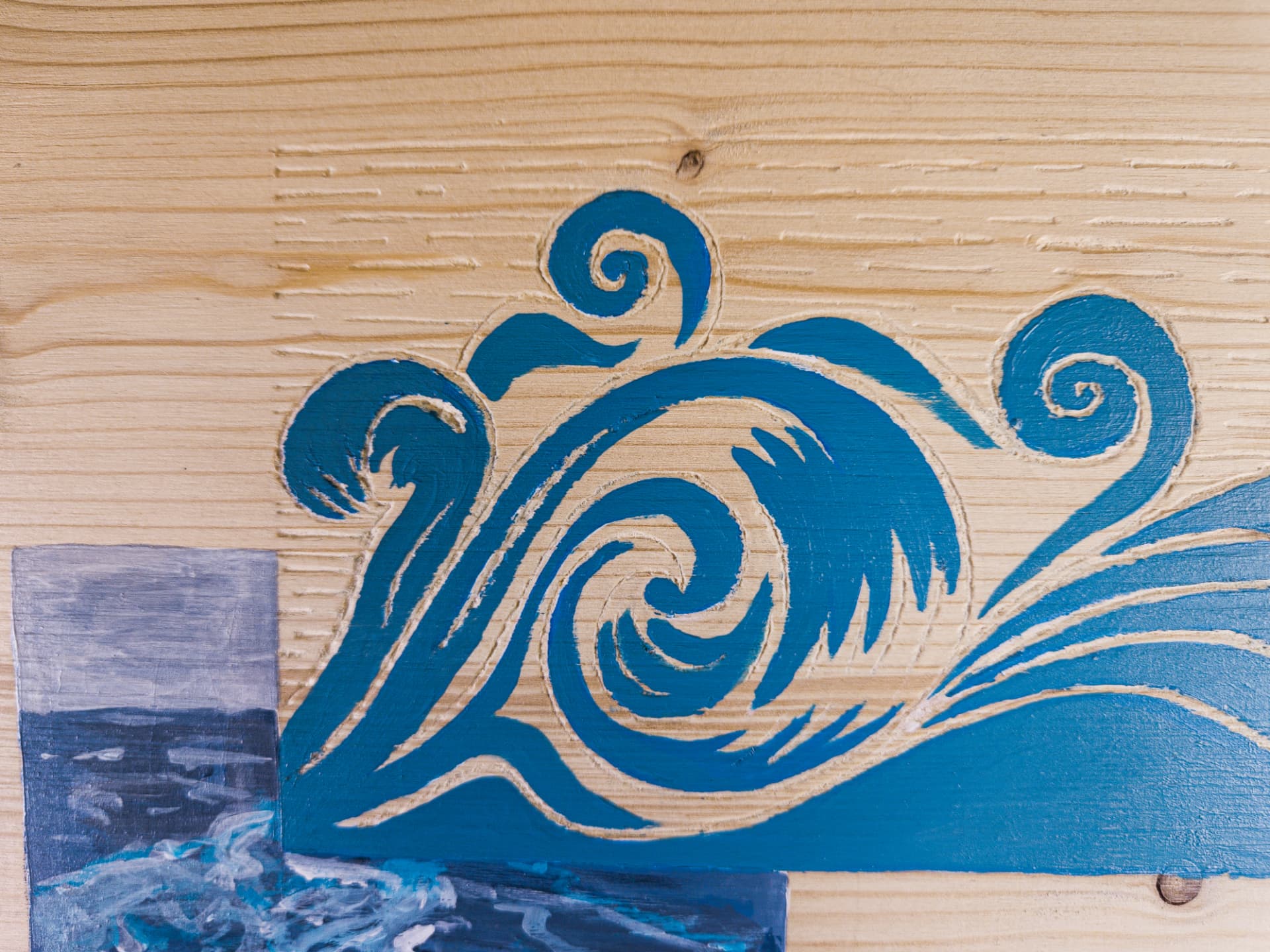 Détail — la volute gravée dans le bois nu
